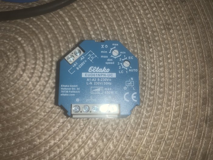 Eltako EUD61NPN-UC dimmer för LED-ljus på texturerad bakgrund med tekniska specifikationer och kopplingsschema.