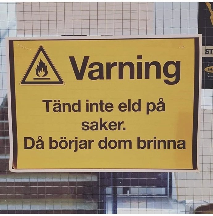 Skylt med texten "Varning: Tänd inte eld på saker. Då börjar dom brinna" och en flam-ikon.