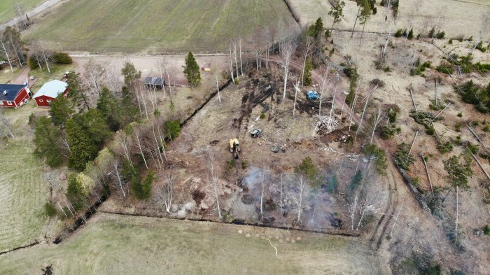 Drönarvy av ett byggprojektområde med delvis röjd mark och byggmaskiner.