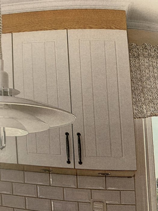 Köksluckor med vertikal panel och svarta handtag, möjlig fråga om tillverkare.