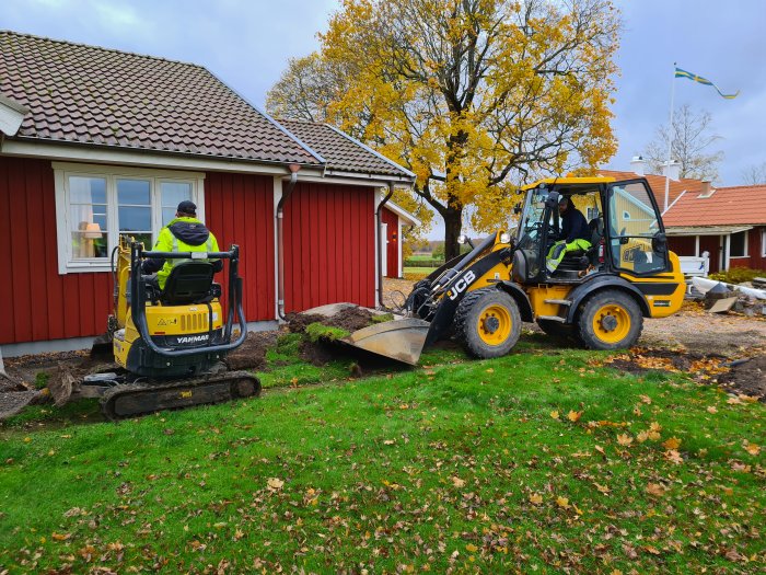 Arbetsfordon i trädgård schaktar för uppgradering av uppfart med granitkantsten och elinstallationer.