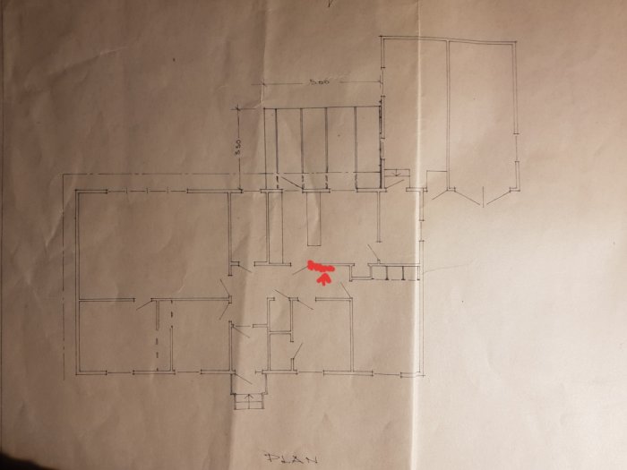 Ritning av en bostadsplan med en vägg markerad med röd pil som ska rivas.