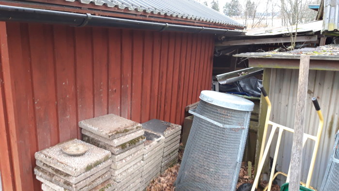 Mellanrum mellan två förråd med skrot och byggmaterial, tänkt för brädgårdsbygge.