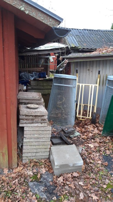 Mellanrum mellan två förråd med diverse byggmaterial och skräp, tänkt för framtida brädgård.