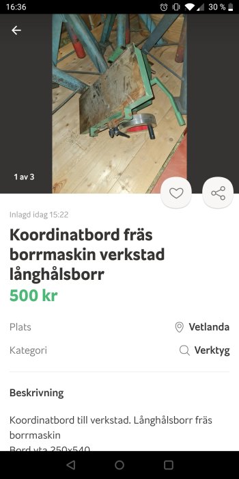 Koordinatbord för verkstad med gröna och röda metallkomponenter på trägolv.