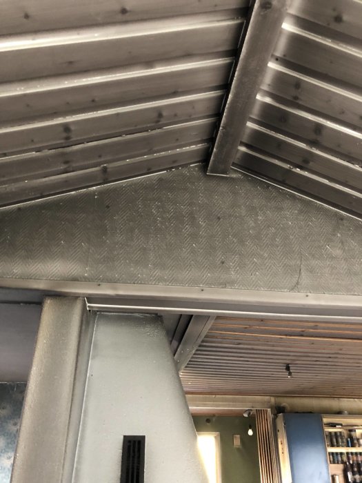 Brandskadat innertak i fritidshus med synlig sot och smält plast, från 60-talet.