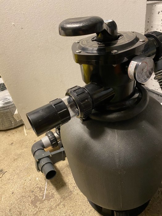 Poolfilter med monterad svart detalj för slangen och manometer, saknar lock och filterbollar.