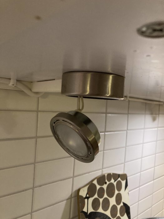 IKEA bänkbelysning med en lampa som behöver bytas, monterad under köksskåp ovanför kakel.