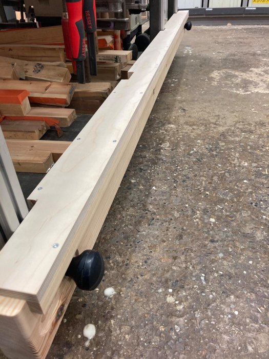 Ny uppgraderad arbetsbänksbalk med trälock, ännu ej fastlimmad filt, i en verkstadsmiljö.