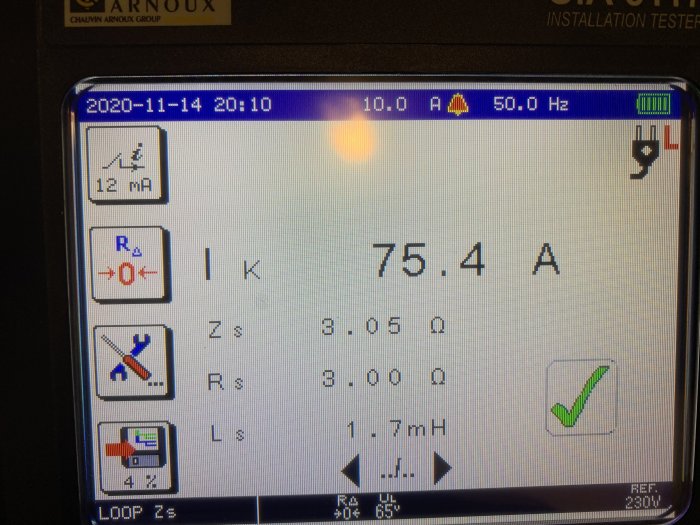 Installationstestare visar en skärm med mätvärden: 75.4 A, och andra elektriska parametrar, med en bock vid godkänt resultat.