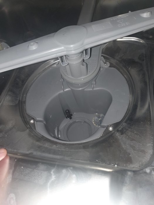 Insidan av en tvättmaskins trumma med synlig mittaxel och öppning för underhåll.