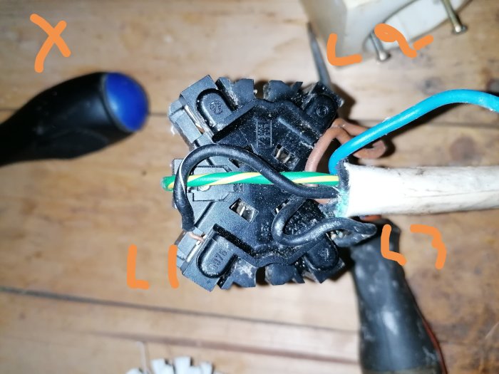 En öppen elektrisk kabelanslutning med markerade faser (L1, L2, L3) och nollan på en väggkontakt.