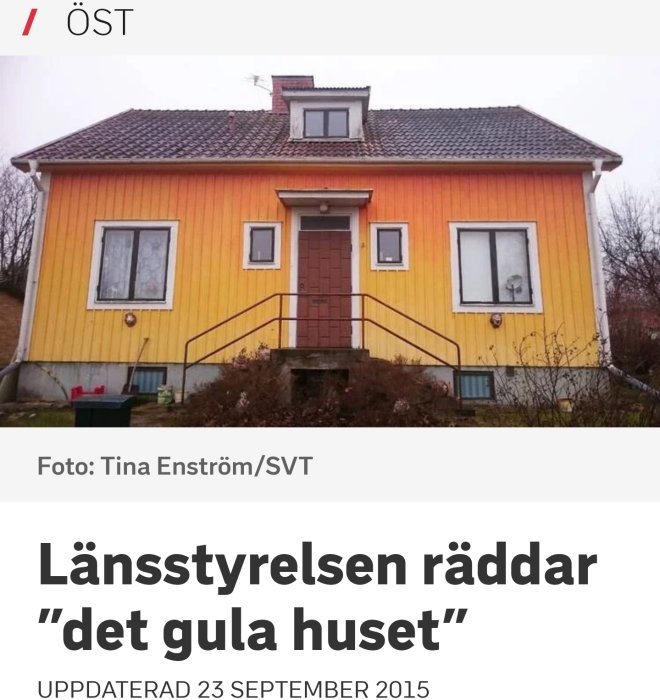 Ett gult hus med rött tegeltak och brun entrédörr i Skänninge, omdiskuterat för sin avvikande färgsättning.