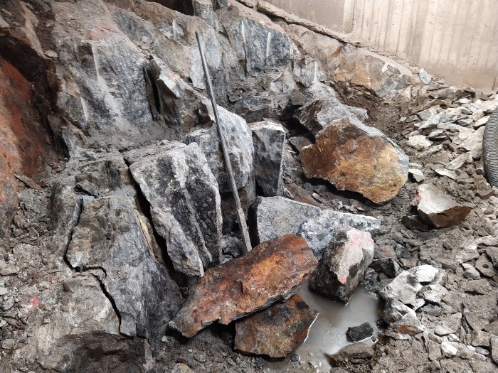 Berggrund med spräckta stenblock redo för efterspräckning vid byggprojekt.