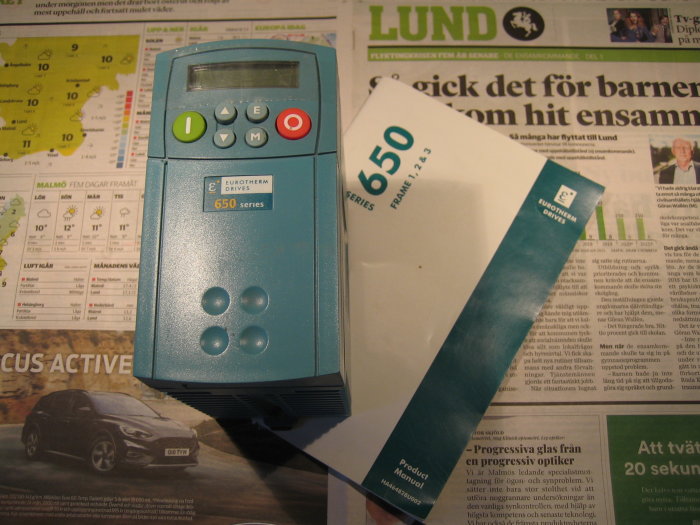 Oanvänd Eurotherm 650-seriens varvtalsreglerare och produktmanual på en tidning med texten Lund.