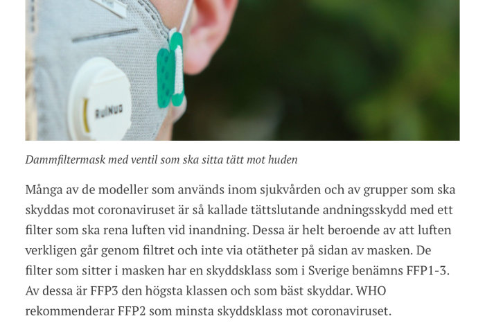 Person som bär en grå dammfiltermask med vit ventil nära ansiktet.