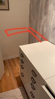 Hörn av rum med omonterad bänkskiva över skåp, markerad tänkt position för regel på vägg.