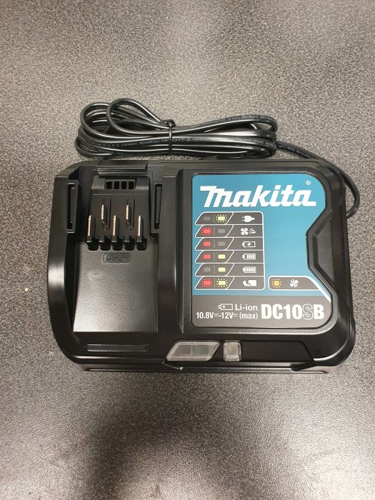 Makita DC10SB batteriladdare för 10.8V-12V Li-ion batterier på en mörk yta.