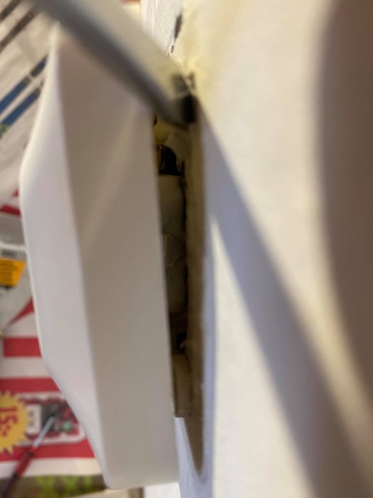 Utplacerat eluttag med en mejsel intryckt bakom, synliga kablar och lucka tyder på fastsittning.