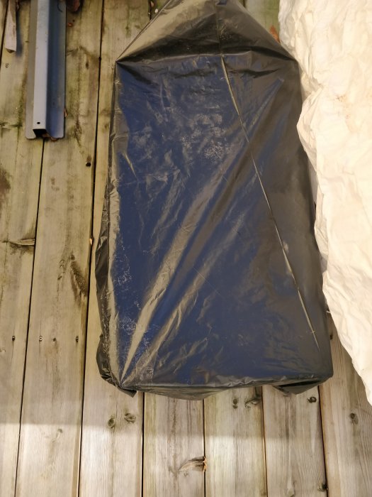 En försluten papplåda täckt med plastpåse på trägolv, används för att röka ek för ett byggprojekt.