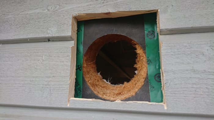 Hål i en yttervägg täckt med ISOCELL Airstop Flex tejp runt kanterna, förberett för ventilationssystem.