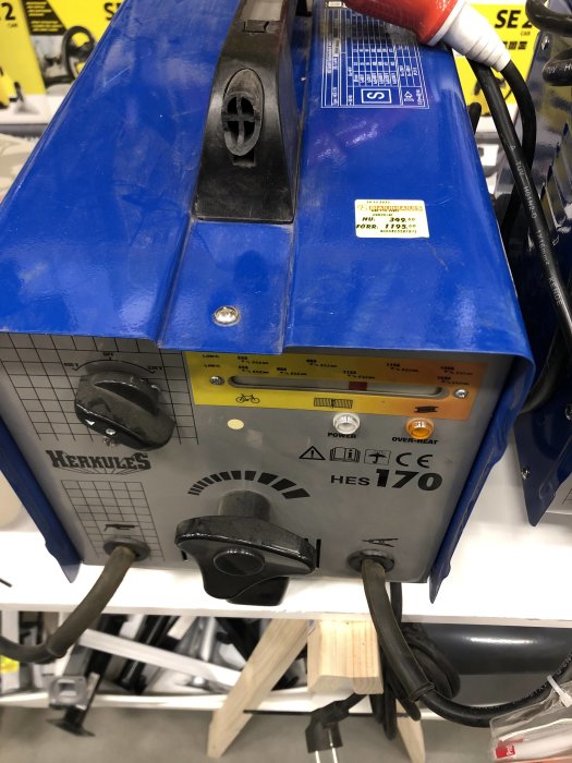 En närbild av en blå pinnsvetsmaskin modell Hercules HES 170 på en hylla, prislapp synlig.