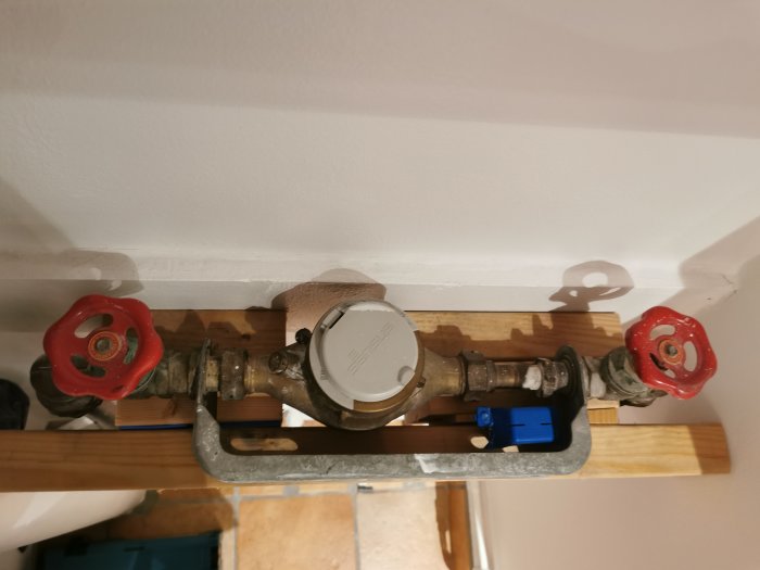 Vattenmätare monterad med tillfällig lösning av träreglar och konsol, redo för ytterligare fixering.