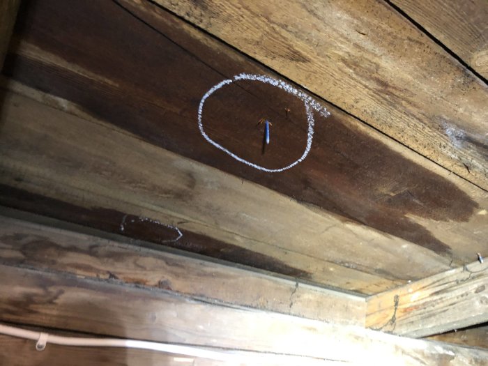 Tak med synliga läckor och pölar på vinden där takreparation pågår.