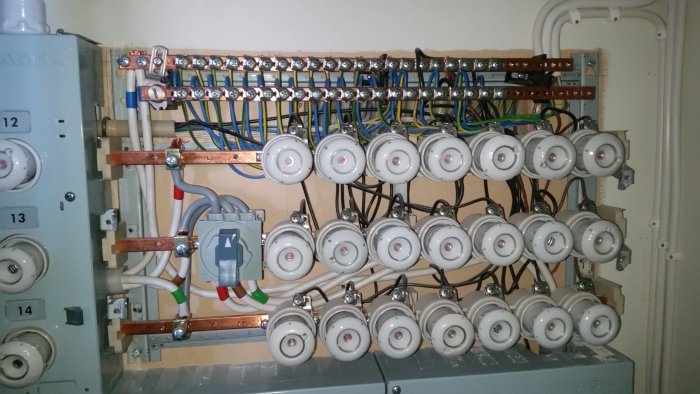 Välorganiserad elcentral från 70-talet med säkringar och kablar.