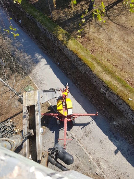 Vy ovanifrån på en skylift vid en gammal kyrkmur, använd i trädfällningsarbete.