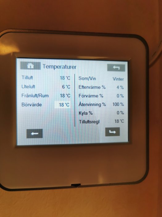 Digital display på en värmepump med temperaturinställningar och effektivitetsinformation för ventilationssystem.