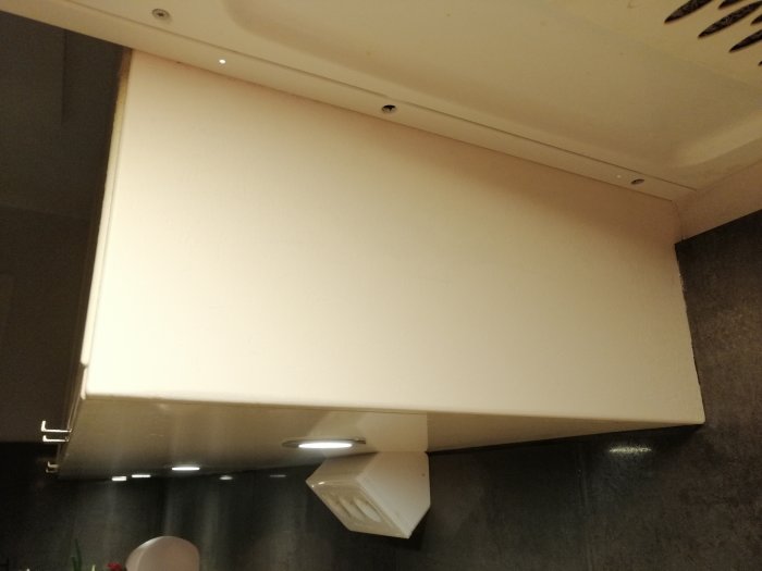 Nymålad del av stommen under köksskåp efter reparation och slipning.