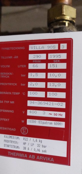 Specifikationsetikett på en Thermia Villa 90s värmepump med tekniska data som volym, tryck och effekt.