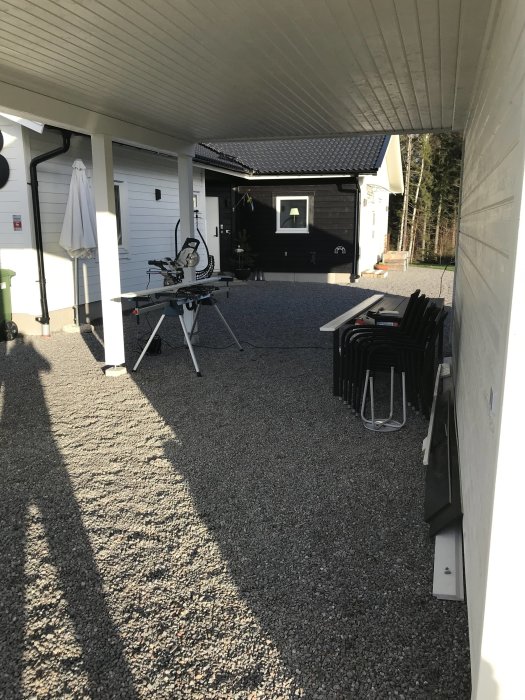 Carport med vitmålat tak och verktyg på bord, väntande elektrikerarbeten för belysning och solceller.