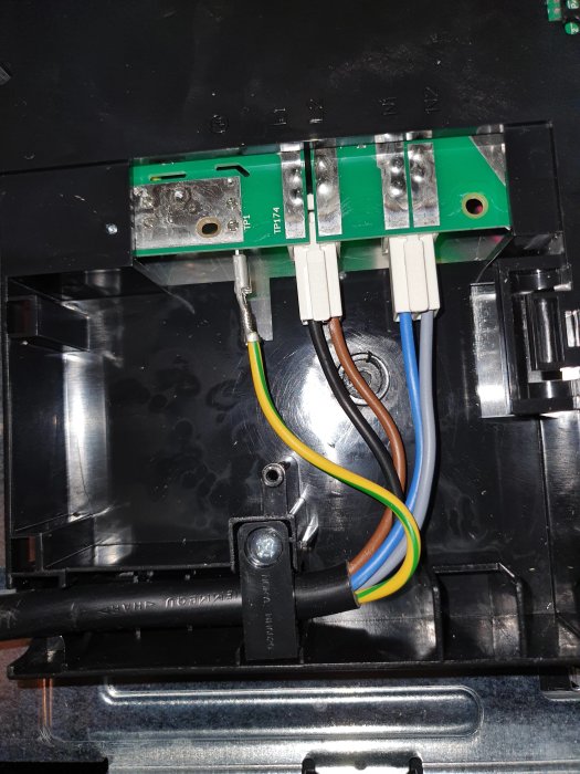 Interiör av en elinstallation med anslutna kablar och terminalblock.