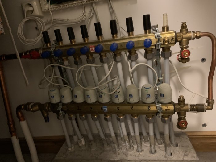 Golvvärmesystem med flödesmätare på slingor och huvudventil för retur men inget inflöde synligt.
