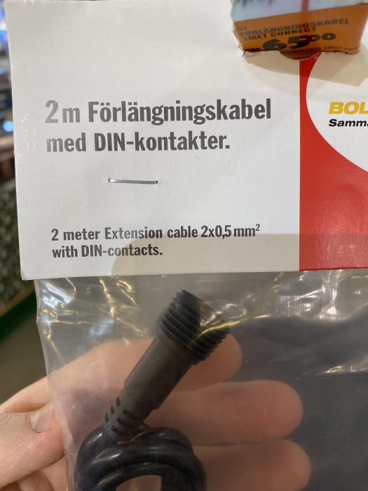 Förpackning med en 2 meter lång förlängningskabel och DIN-kontakter med text som anger kabelns dimension på 0,5mm2.