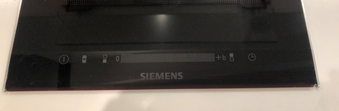 En induktionshäll från Siemens med synliga skador i hörnen.