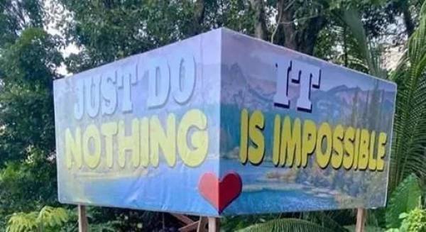 Tärningsformad skulptur med texten "JUST DO NOTHING" och "IT IS IMPOSSIBLE" när den ses från två vinklar, med ett hjärta emellan.
