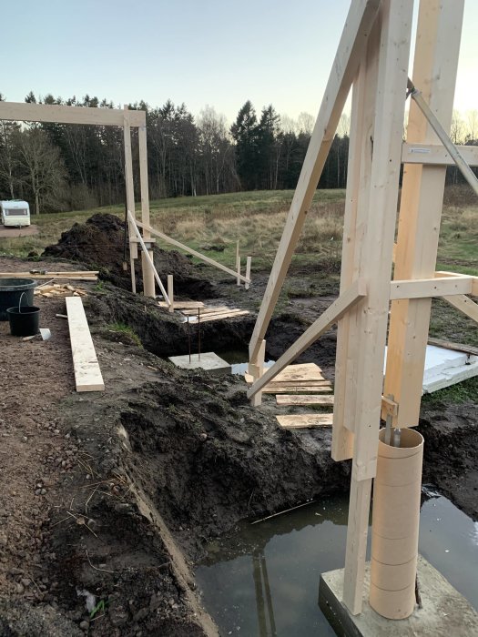 Förberedelsearbete för bygge av carport med provisoriska upplag för limträbalkar och stolpar intill gjutningsarbeten.