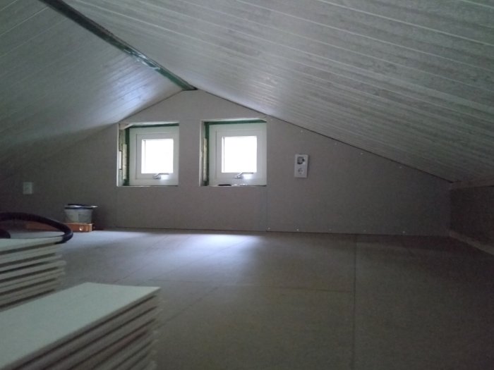 Nyinstallerat golvspån och utsida av reglade väggar på ett loft under konstruktion.