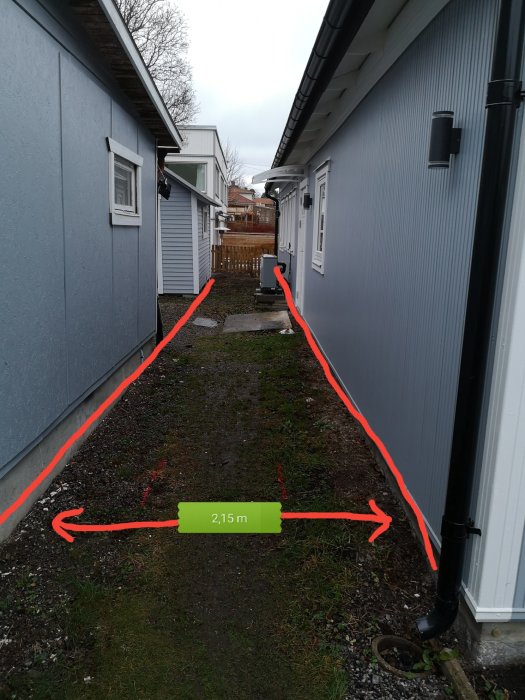 Gångväg mellan hus och garage med måttmarkeringar för planerad altanbygge, 2,15 m bredd angivet.