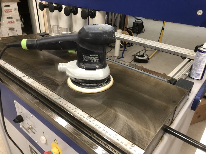 Slipmaskin från Festool används för underhåll på en verktygsmaskin i en verkstad.