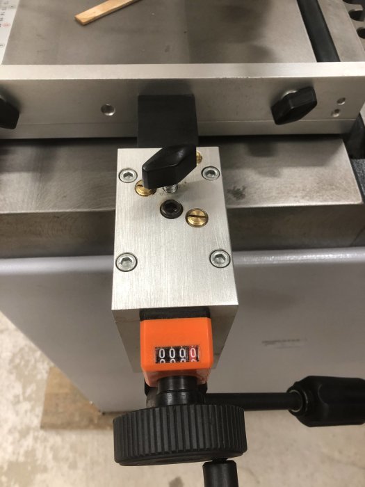 Verktygsdetalj av metall med nollställd räknare på en maskin i en verkstad.