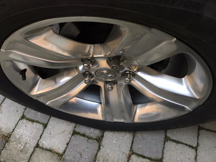 Bilfälg med nya triple-nickel chrome plated muttrar monterade, ersättning för rostfria OEM-muttrar.