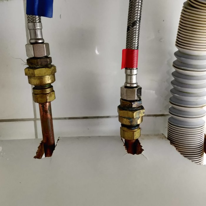 Bild av två vattenrör från en vägg, ena med blå tejp märkt, båda utan yttermutter för blandarfäste.