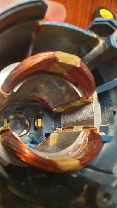 Inre delen av en kantfräs som visar kopparband och spolar, tecken på användning och möjlig skada.