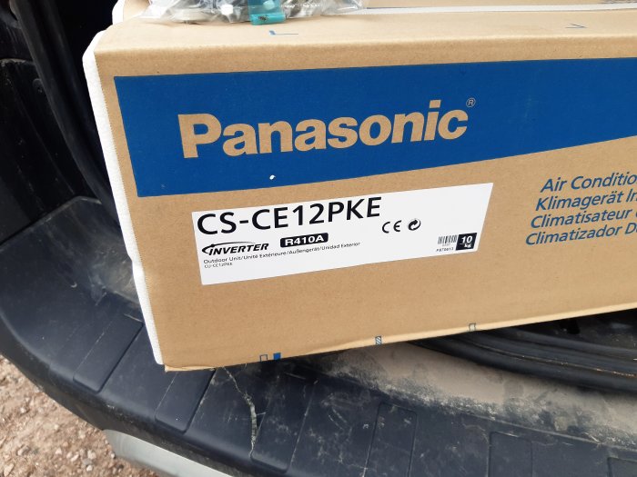 Kartong med Panasonic värmepump modell CS-CE12PKE som ligger på ett fordon.