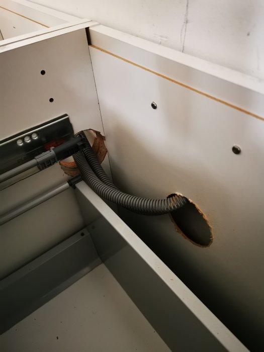 Elinstallation i skåp med kopplingsdosa och genomföringshål för kabelskyddsrör.
