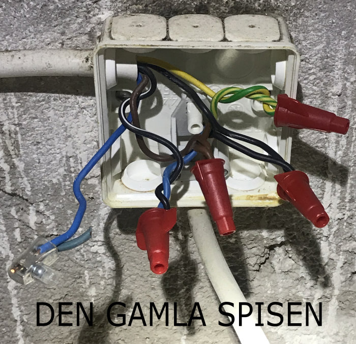 En öppen väggdosa med utsatta elektriska ledningar och skyddskåpor.